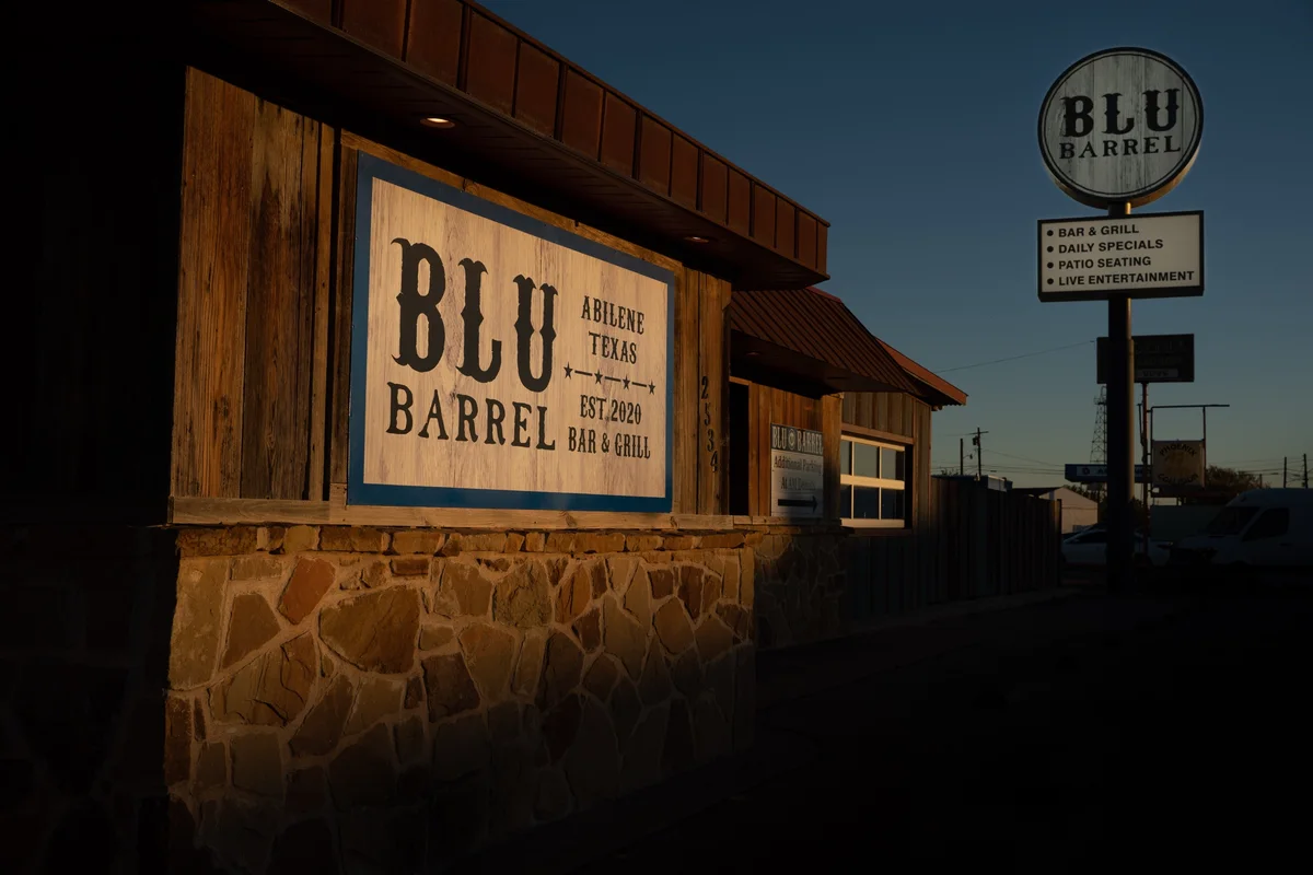 The Blu Barrel building and road sign at dusk